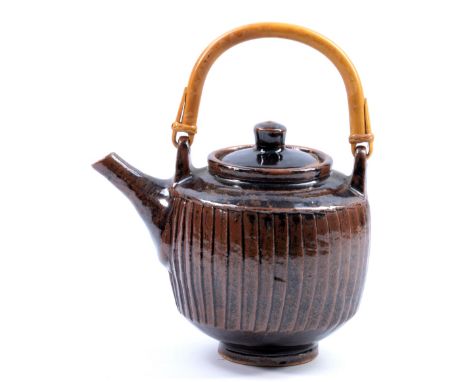 DAVID LEACH (1911-2005) for Lowerdown Pottery; a fluted stoneware teapot with cane handle, tenmoku breaking to kaki glaze, im