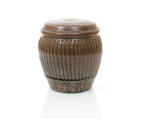 •Mike Dodd (born 1943) a cut-sided stoneware jar and cover, covered to the foot in an ash glaze impressed seal mark, 21.5cm. 