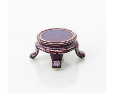 A Ruskin Pottery high-fired stoneware stand  by William Howson Taylor,  circular on four flaring feet, covered in a sang de b