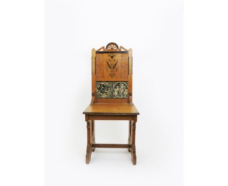 A Gothic Revival oak hall chair, with ebonised wood detailing, and decoration to the back,  inset with two Minton's Early Eng