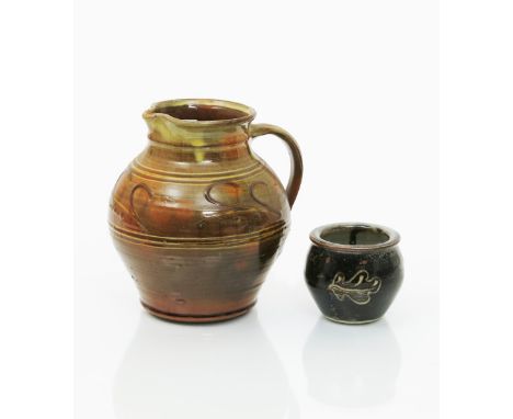 Winchcombe Pottery a slip glazed earthenware jug, decorated with simple grass motif, two piecrust rimmed slipware dishes and 