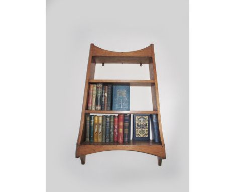 An oak wall mounted shelf,  tapering form with three shelves, and an Arts and Crafts bookshelf 91cm high, 61cm. (2) 