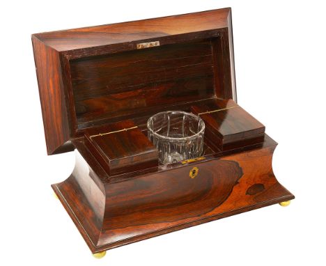 A George IV rosewood tea caddy, 1820sof waisted sarcophagus form, the hinged lid revealing a facetted glass mixing bowl flank