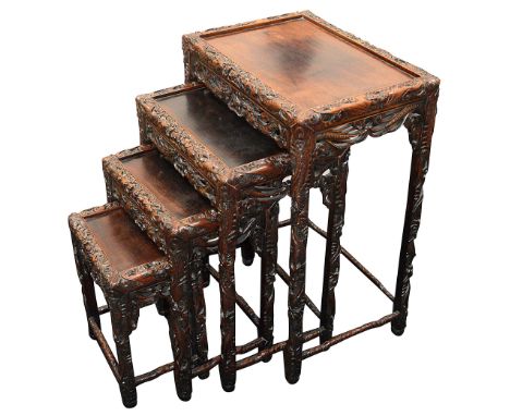 A Chinese nest of four hardwood tables, circa 1900the edges, legs and openwork friezes with carved dragons, flowerheads, bats