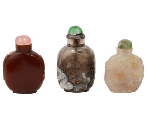 Three Chinese hardstone snuff bottles Qing/ Republicanfirst smokey quartz, relief carved with two Foo dogs with a ball in a m