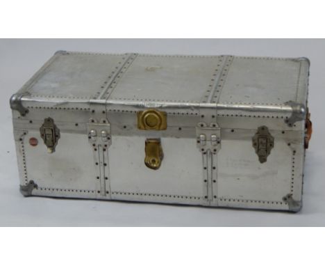 A 20thC Suzuki metal cased industrial travel trunk, with a part studded outline and heavy locks, 36cm high, 83cm wide, 50cm d