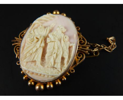 A 9ct gold framed cameo brooch, the cameo with intaglio design of lady, gentleman and child, in elaborated frame, 4cm wide. 