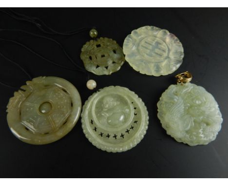 Five modern jade style pendants, each of carved circular design, some on string necklaces (5). 