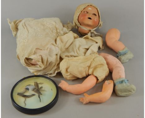 A British made doll, with ceramic head and body (AF), and a modern feather picture