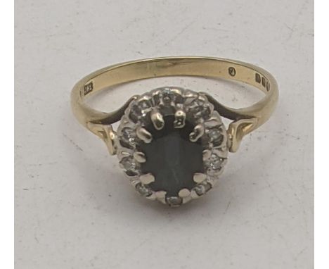 A 18ct yellow gold and white gold diamond and sapphire cluster ring, oval cut sapphire in a 10 claw setting surrounded by 10 