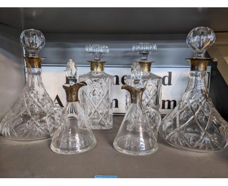 A pair of silver collared and cut glass whisky decanters and a pair of matching ships decanters, along with a pair of silver 