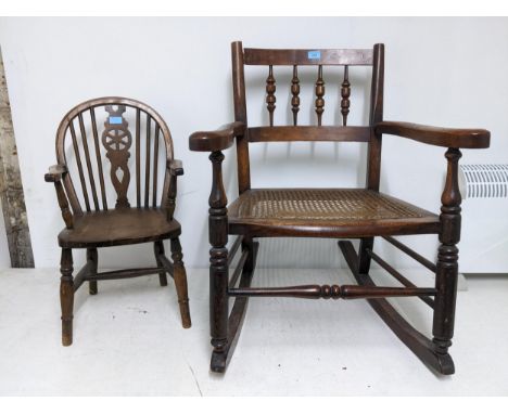 A 19th century cane seated rocking chair turned spindle back out swept arms, on ring turned legs united by a turned eliptitur