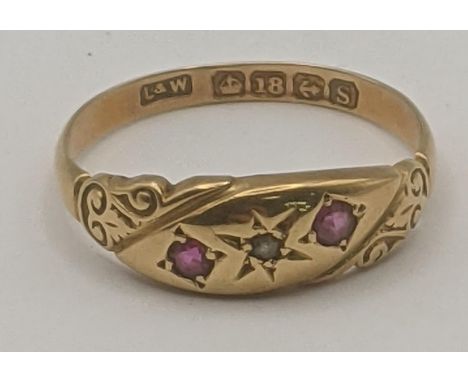 An 18ct yellow gold ruby and diamond gypsy ring with a central diamond in a starburst setting flanked by rubies, size N, 2.1g