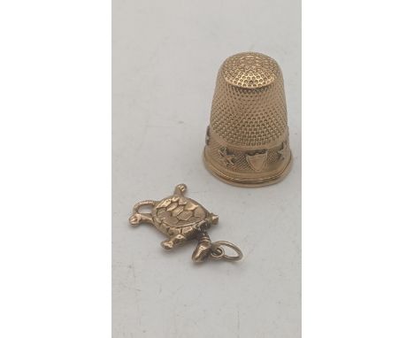 An yellow metal thimble tested as 14ct gold 4.4g together with a 9ct yellow gold charm fashioned as a turtle A/F 0.5gLocation