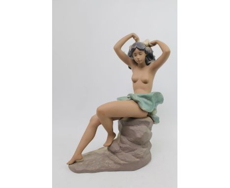 Nao Gres figure of a semi nude on rocky outcrop. 38cm in Height 