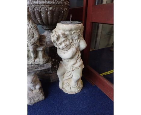 A RECONSTITUTED STONE SUNDIAL in the form of a cherub, 76cm high