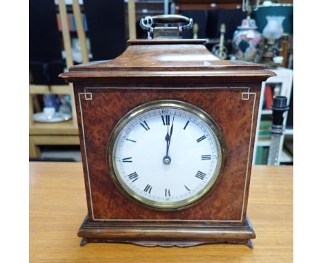 AN EARLY 20TH CENTURY BURR WALNUT CASED MANTEL CLOCK with white enamel dial and French movement, 21cms high