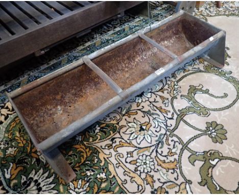 A GALVANISED METAL ANIMAL FEEDING TROUGH (drilled for planting), 122cms long, and another similar, 93cms long
