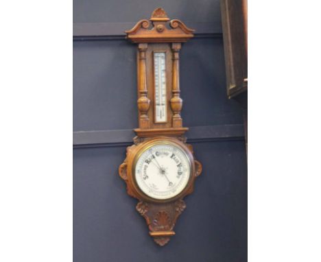 VICTORIAN CARVED OAK ANEROID BAROMETER CLOCK8 inch white dial, gilt and steel hands, the carved pediment above a glazed therm