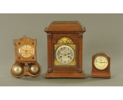 An early 20th century German walnut wall alarm clock, the spring driven movement striking on two bells.  30 cm high and two o
