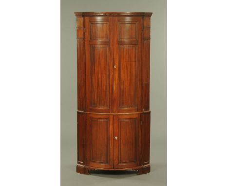 A 19th century mahogany standing bowfronted double corner cupboard, with panelled doors raised on bracket feet.  Height 220 c