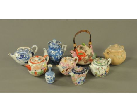 A collection of eight late 19th century and later Oriental teapots, various.  Tallest including wicker handle 18 cm. CONDITIO