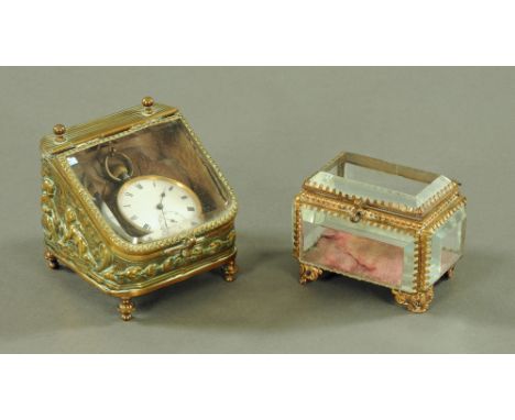 A Victorian embossed brass watch holder, with slope front and gun metal pocket watch within and trinket box.