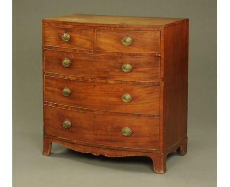 A 19th century mahogany bowfronted chest of drawers, two short and three long with brass drop handles with embossed oval back