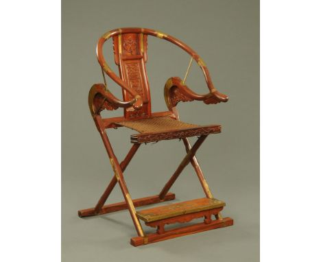 A Chinese hardwood horseshoe shaped folding chair, with brass fittings.  Height to top of back 106 cm, width across arms 66 c