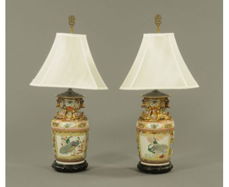 A pair of Chinese porcelain vases, in the Canton style converted to table lamps and each with wooden base.  Height 86 cm. CON