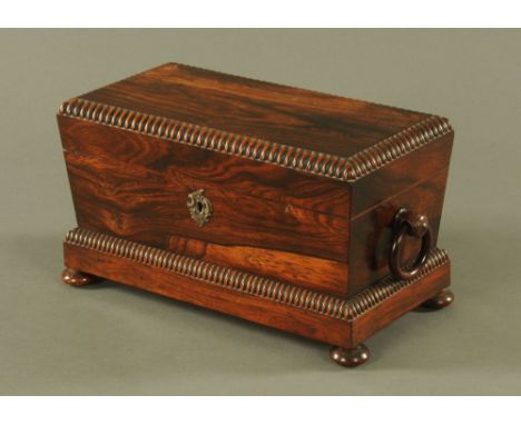 A Regency/William IV rosewood tea caddy, with interior compartments and glass bowl and raised on bun feet.  Width 32 cm (see 