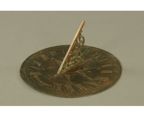 An antique brass sundial, marked Festina Lente.  Diameter 25 cm.