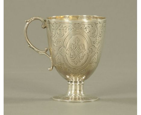 A Victorian silver christening mug, the body engraved with leaf scrolls and open cartouche by Arthur Sibley London 1867.  9.5