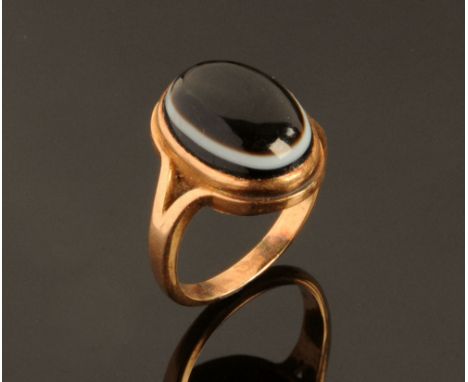 A Victorian rose gold coloured metal and banded agate ring, with oval cabochon stone.  Ring Size M.