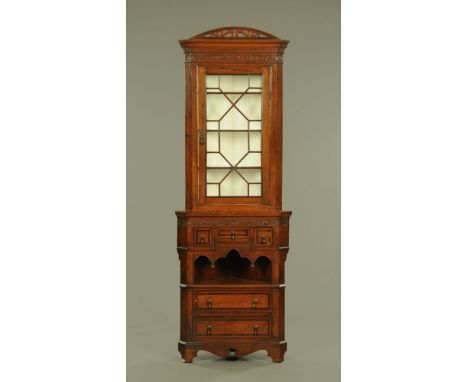 A George III style mahogany standing corner cupboard, with pierced pediment and oak leaf carved frieze above a glazed door, t