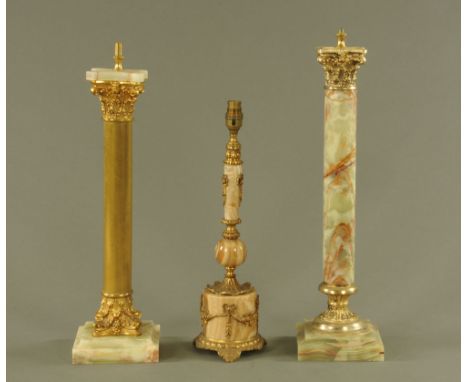 Three lamp bases, two onyx with Corinthian capitals and another.  Tallest 59 cm.