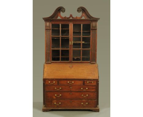 A Georgian mahogany bureau bookcase, with swans neck pediment above a pair of glazed doors opening to shelves, the base with 