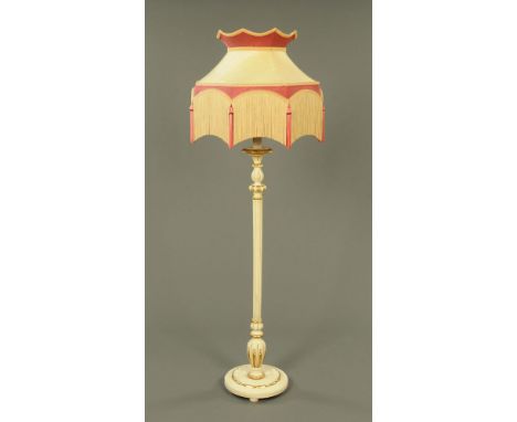 A white and gilt painted lamp standard, with candle type light fitting and with tasselled shade. 
