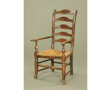 A 19th century elm ladder back open armchair, with scrolled uprights and rush seat on turned legs.