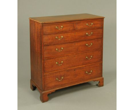 A George III oak chest of drawers, with moulded edge above two short and four long graduated drawers with brass drop handles 