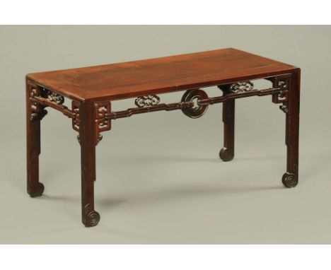 An antique Chinese hardwood low table, with pierced frieze and moulded legs with scroll feet.  Height 61 cm, width 121 cm, de