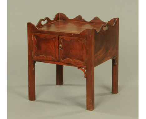 A Chippendale style mahogany bedside cabinet, with tray type top and pair of panelled cupboard doors raised on square chamfer