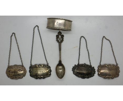 Four decanter labels (whisky x2 and sherry x2), with a silver tennis trophy spoon dated 1930 and a napkin ring, combined 107g