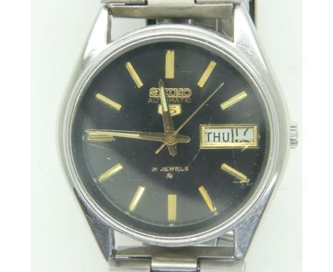 SEIKO 5: steel cased gents wristwatch, black dial with gold baton chapters and day/date aperture, on a steel bracelet, workin