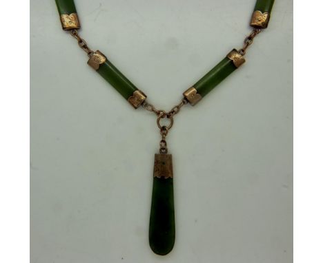 An early 20th century 9ct gold necklace, the links separated with gold-mounted jade panels and a further larger jade panel pe