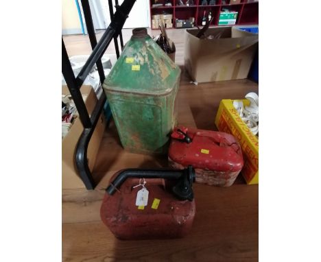 Two red metal petrol cans and vintage green petrol can