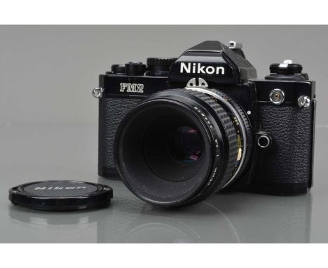 A Nikon FM2 SLR Camera, black, serial no 8675138, shutter working, meter responsive, self timer working, body G, brassing & p