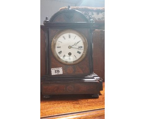 A Victorian Ebonised and Amboyna Mantel Timepiece of Arched Outline; with 9cm. enamel dial with Roman numerals, 28cm. high. 