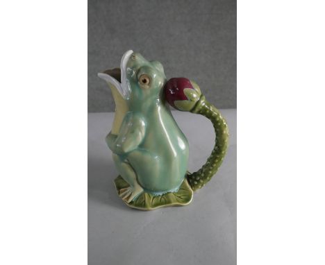 A Majolica glazed pitcher in the form of a gaping frog with waterlily bud handle, stamped to the base. H.25 W.16cm 
