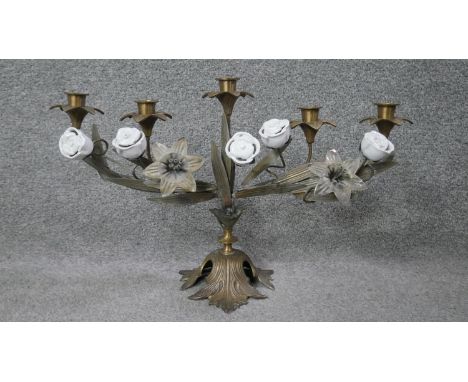 A brass and ceramic five branch candelabra with rose and lily design and on a foliate base. H.32 W.46 D.16cm 
